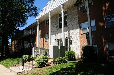 Wilder Manor Exterior photo of a two story apartment building. There is a staircase leading to the main entry, and balconies on both the first and second floors. Trees, shrubs and green grass landscape the area.
