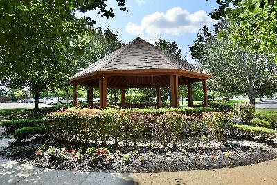 Yorkshire Meadow gazebo photo showing the gazebo located next to a parking lot. Several bushes and trees highlight the landscape.