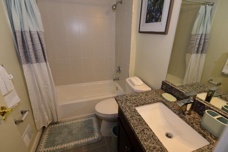 Bathroom at Yorkshire Meadows showing a tub with shower, new toilet, sink with granite countertops and ceramic tile floor.