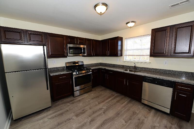 Yorkshire Meadows kitchen photo showing new cabinets, granite countertops, stainless steel appliances and wood grain flooring