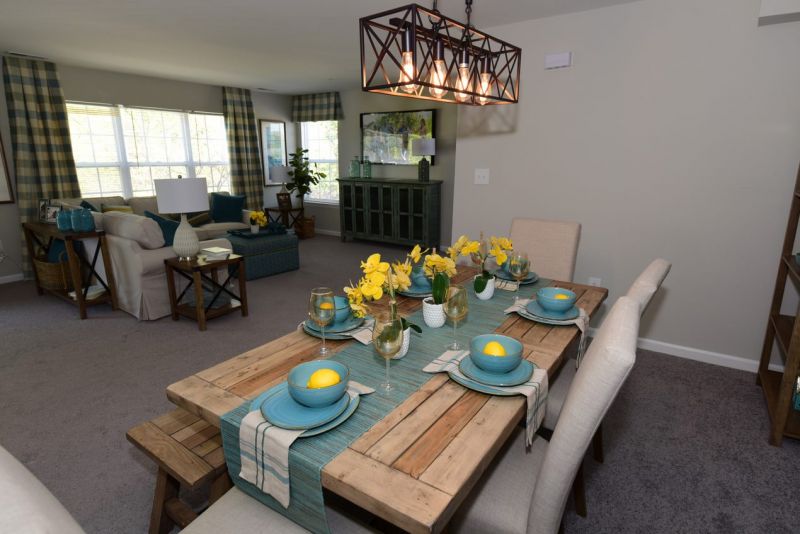 Maebrook at Renaissance interior photo of a dining room featuring a dining room with table with seating for 6 and an overhead light fixture. Living room can be seen in the background.
