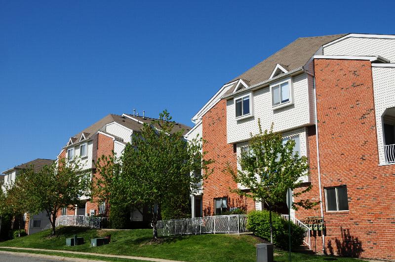 Harbortown Terrace exterior image showing two large apartment buildings, surrounded by green grass and trees. A sidewalk leads tenants past to these buildings.