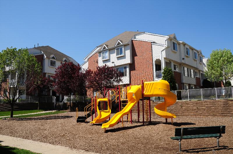 Harbortown Terrace exterior photo showing a playground with several pieces of play equipment including multiple slides and a bench