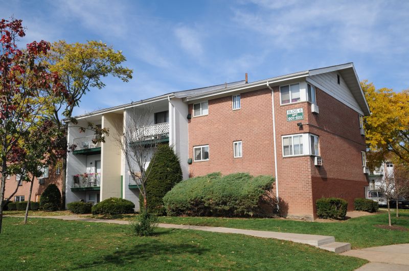 State Fayette Exterior photo showing a brick exterior and several balconies. Several bushes and trees highlight the landscape.