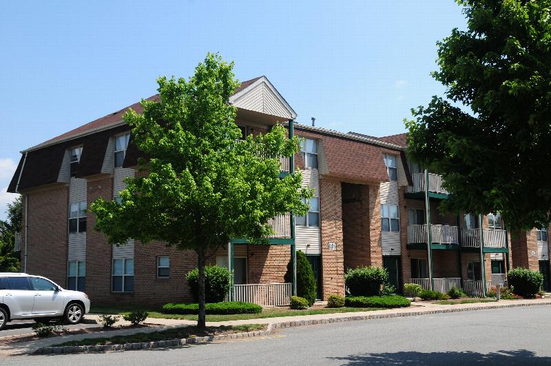 Rivendell Village Exterior photo showing a brick and vinyl exterior and several balconies. Several bushes and trees highlight the landscape.