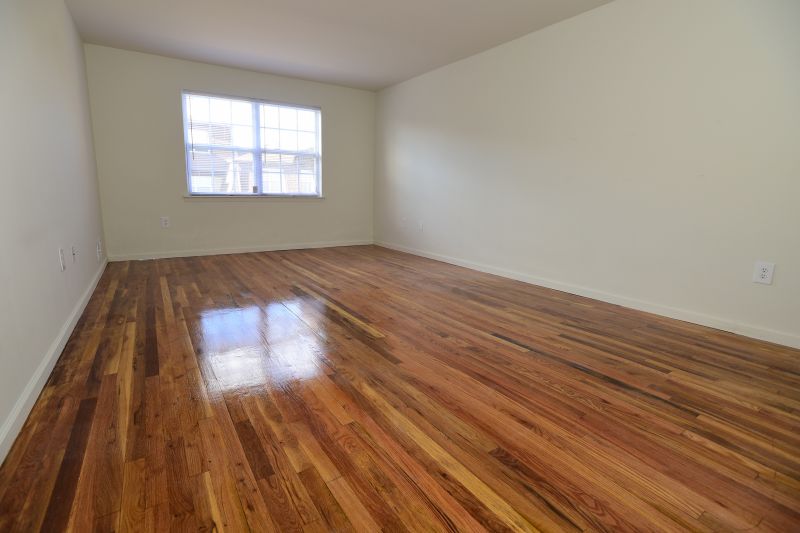 Woodbridge Center Plaza photo of a large bedroom shows hardwood floors and a window for allowing in natural light.