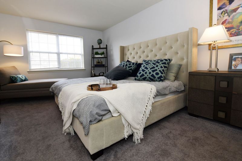 Photo of a bedroom showing new wall to wall carpet, fresh paint, a complete bedroom set and a window to allow for natural light.