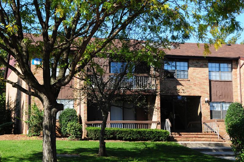 Woodbridge Terrace Exterior photo showing a brick exterior and several balconies. Several bushes and trees highlight the landscape.