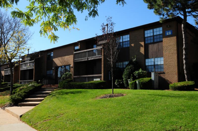 Woodbridge Terrace Exterior photo showing a brick exterior and several balconies. Several bushes and trees highlight the landscape.