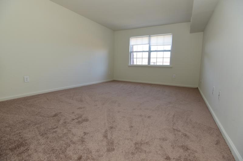 Woodbridge Terrace Bedroom photo showing a bedroom with carpet flooring. Two windows allow plenty of natural light to enter the room.