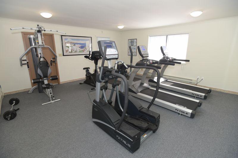 Woodbridge Terrace Gym photo showing two treadmills, an elliptical, an exercise bike and various exercise equipment.