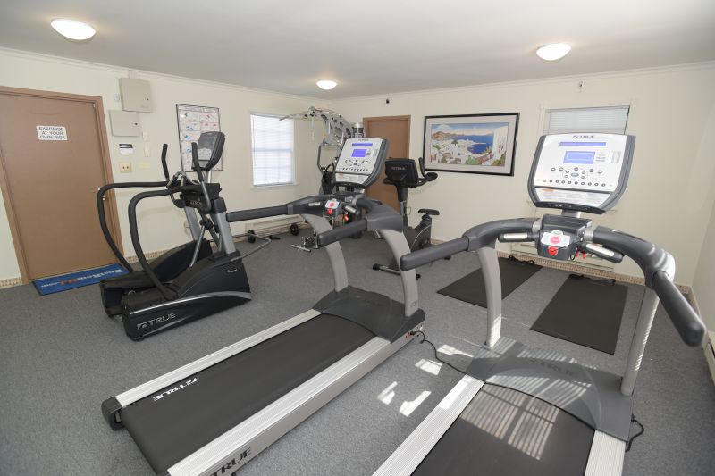 Woodbridge Terrace Gym photo showing two treadmills, an elliptical, an exercise bike and various exercise equipment.