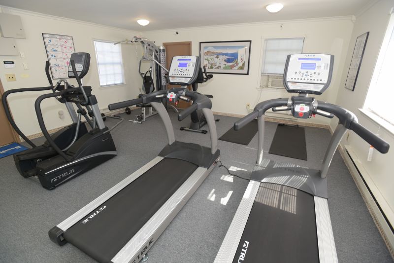 Woodbridge Terrace Gym photo showing two treadmills, an elliptical, an exercise bike and various exercise equipment.