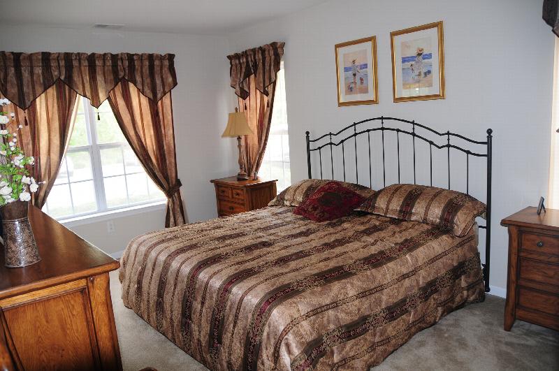 Park Terrace Master Bedroom photo showing a queen sized bed with two nightstands and a dresser on the opposite wall. There is wall to wall carpeting, and several windows to allow for natural light.