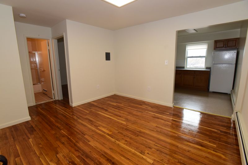 Woodbridge Village dining room area shows hardwood floors leading to a bathroom and to the kitchen.