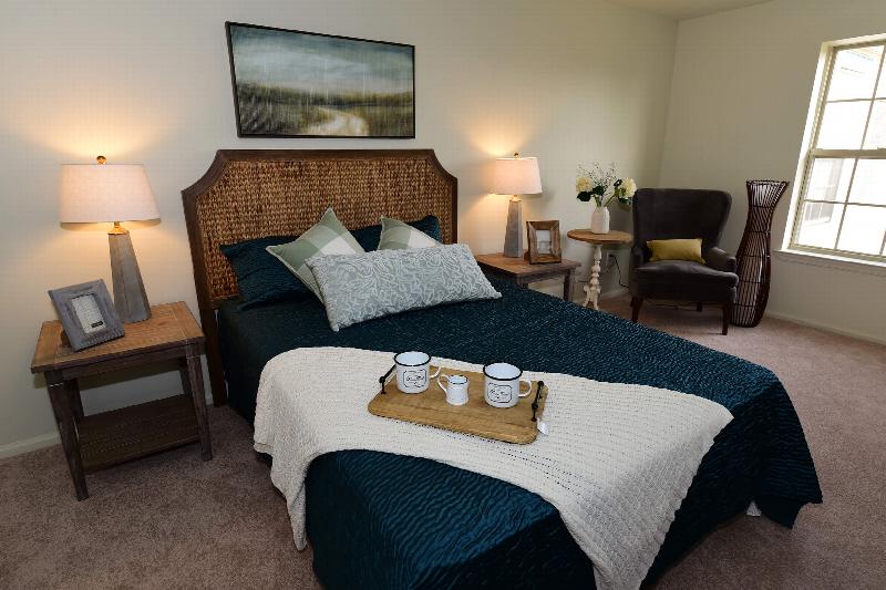 Yorkshire Village exterior showing several balconies and a sign for the rental office. Several bushes and trees highlight the landscape.