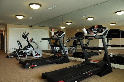 Village at Stratford for ages 55 and above exercise room shows various equipment including treadmills and a stationary bike.