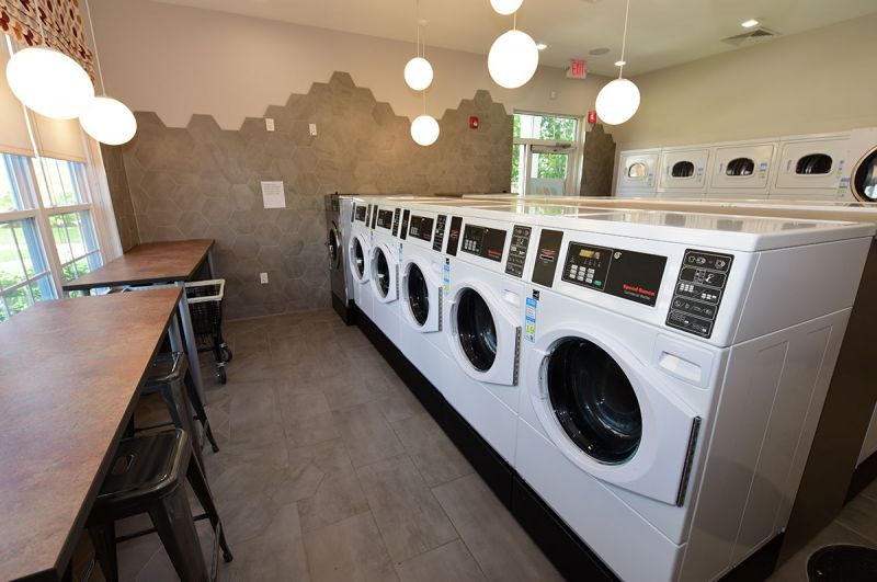 Blueberry and Edison Village Community Clubhouse interior image showing the brand new laundry room with multiple washers, dryers and seating area.