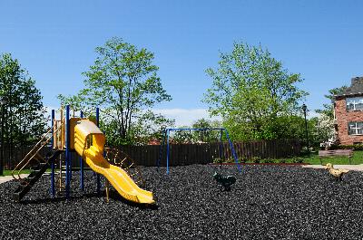 Homestead Village playground photo showing various pieces of equipment including a slide and swing set.