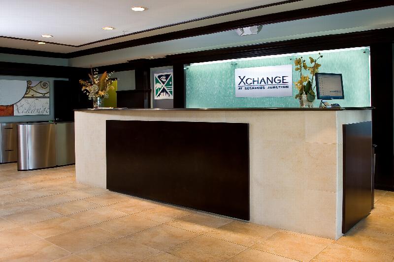 Helix at Xchange Affordable photo of interior lobby entrance showing a large concierge desk station and ceramic tiled flooring