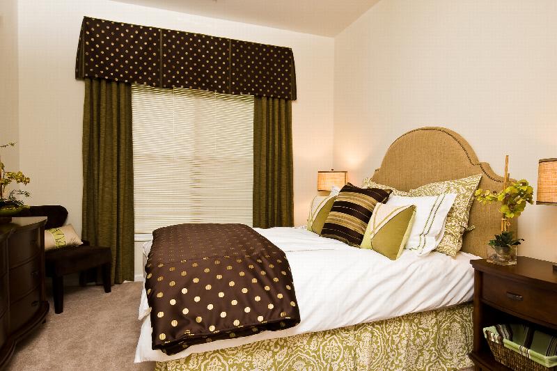 Helix at Xchange Affordable interior photo of third bedroom with queen sized bed and two night tables on either end.  A dresser and large window with valance can be seen in the background.  