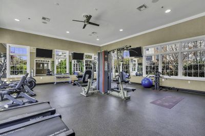 Interior photo of the gym inside the clubhouse at Princeton Terrace in West Windsor showing the large mix of cardio and weight training equipment.
