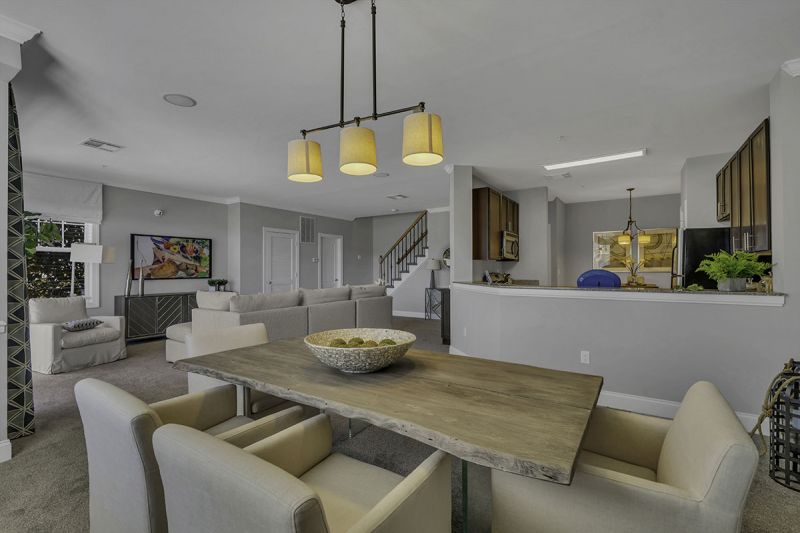 Interior Photo of the model at Princeton Terrace at West Windsor showing the dining area with table and chairs. You can also see the living room and into the kitchen