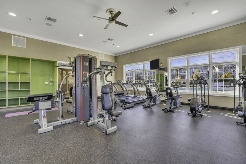 Interior photo of the gym inside the clubhouse at Princeton Terrace in West Windsor showing the large mix of cardio and weight training equipment.