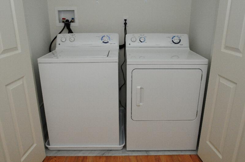 Photo of the full sized washer and dryer in a separate laundry closet at Harbortown Heights.