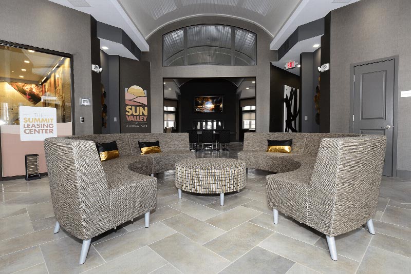 Photo of a seating area in the lobby of the Summit Club at Sun Valley. Entrance to the Leasing Center can be seen on the left.
