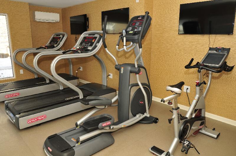 Autumn Hills fitness center photo shows an exercise bike, an elliptical and two treadmills. Three flat screen TVs are on the wall