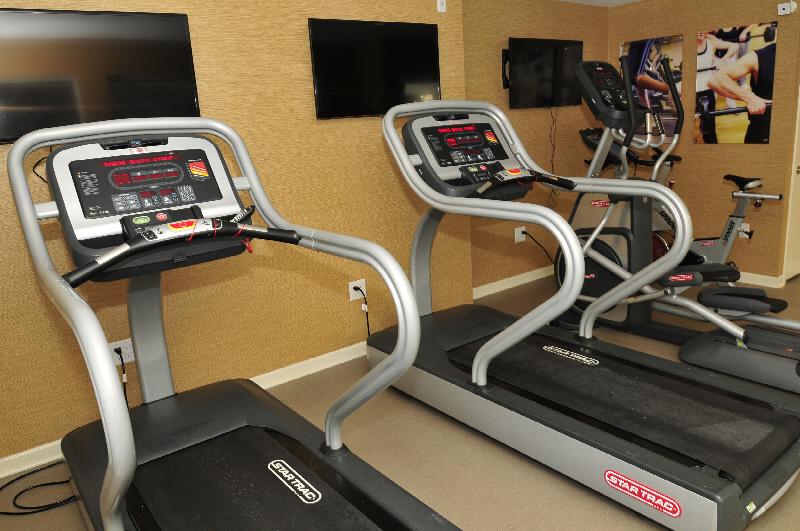 Autumn Hills fitness center photo shows an exercise bike, an elliptical and two treadmills. Three flat screen TVs are on the wall