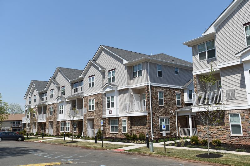 Colonial Heights exterior photo showing a 3 story building with stone exterior on the lover level, and siding on the upper levels. Windows and balconies are also shown.