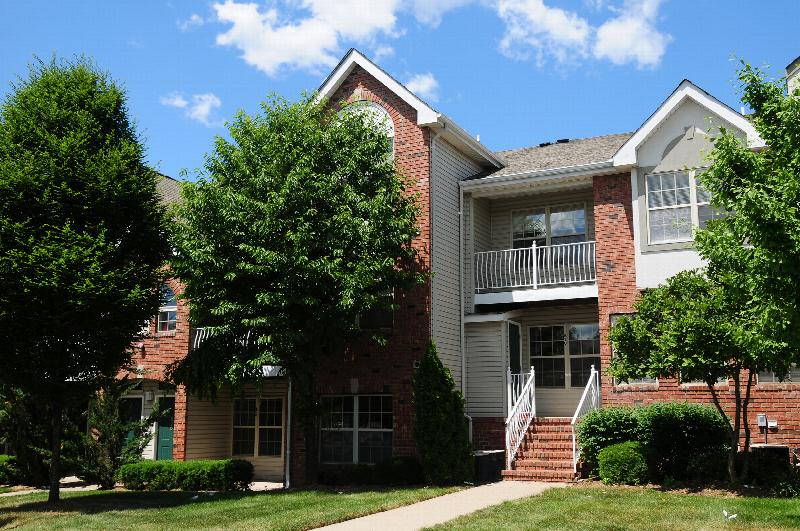 Pike Run Village Exterior photo showing several balconies. Several bushes and trees highlight the landscape.