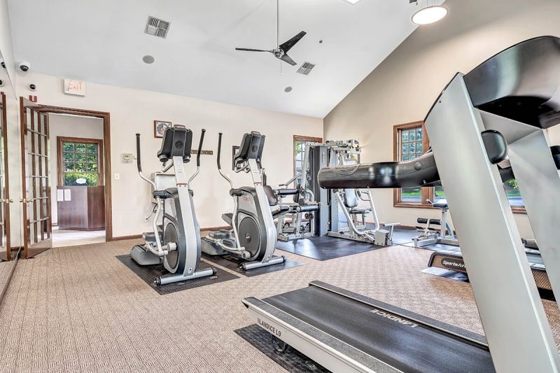 Interior photo of the Pike Run Community Clubhouse, showing the indoor gym with various pieces of cardio and strength training equipment.