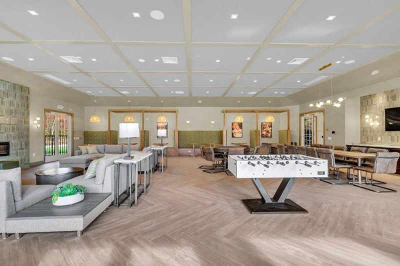 Interior photo of the clubhouse at Woodhaven showing a foosball table inside the great room with multiple seating areas.