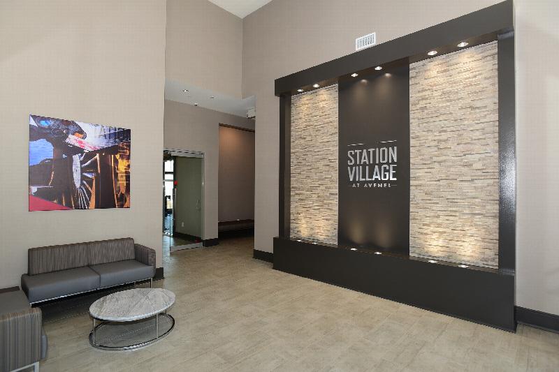 Station Village at Avenel photo of the clubhouse entry showing a seating area, and a light Station Village entry sign.