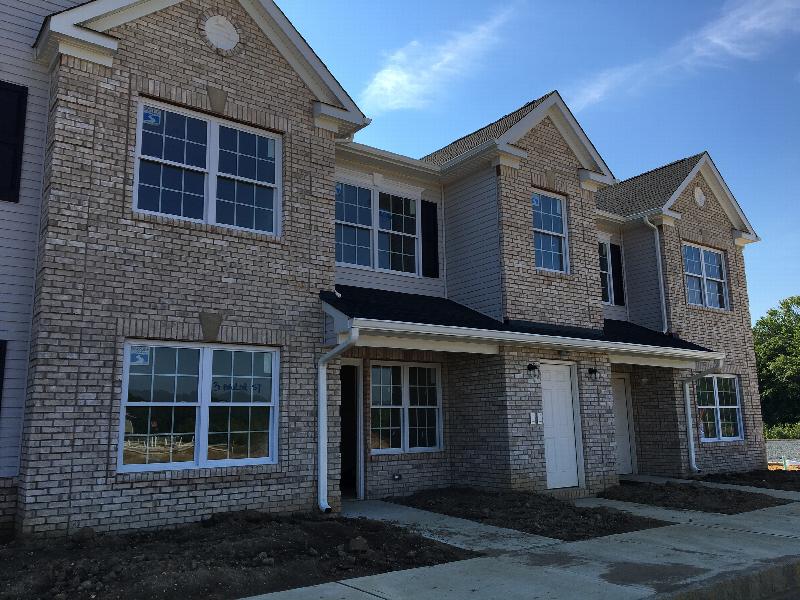 Stratford Terrace photo of the exterior shows a new brick apartment building with sidewalks leading up to entry doors.