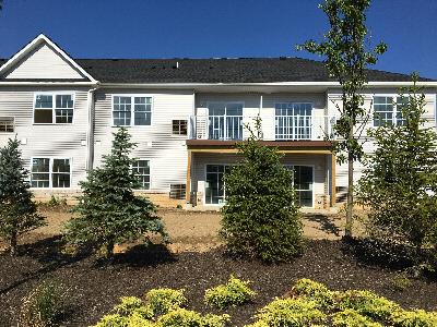Stratford Terrace photo of the exterior shows the back of a new brick apartment building doors that lead out to balconies. There is newly planted landscaping with mulch.