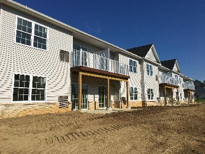 Stratford Terrace photo of the exterior shows the back of a new brick apartment building doors that lead out to balconies or patios.