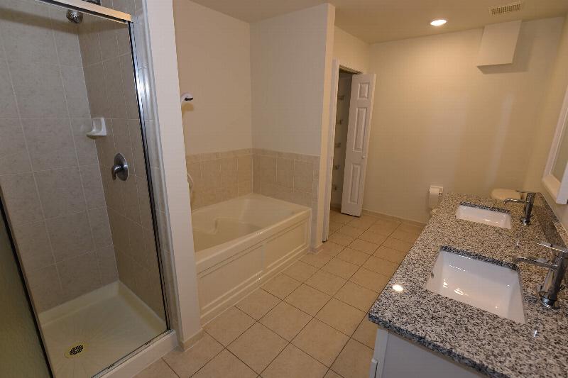 Pike Run Meadows interiot photo showing a bathroom with granite counter tops, full size tun, separate shower stall and a toilet.