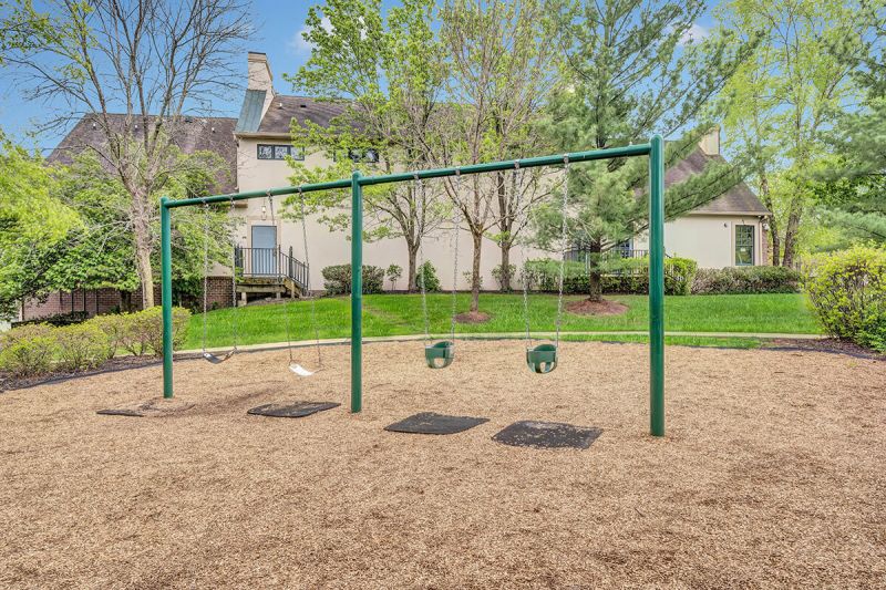 Exterior photo of a playground at Pike Run, showing a swing set.